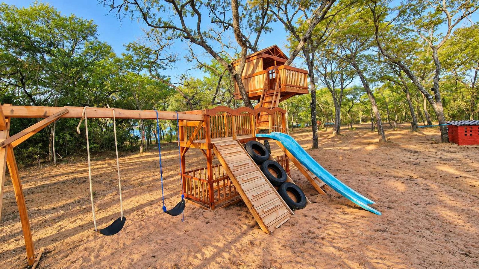 Wooden playground with swings, a slide and a climbing tower