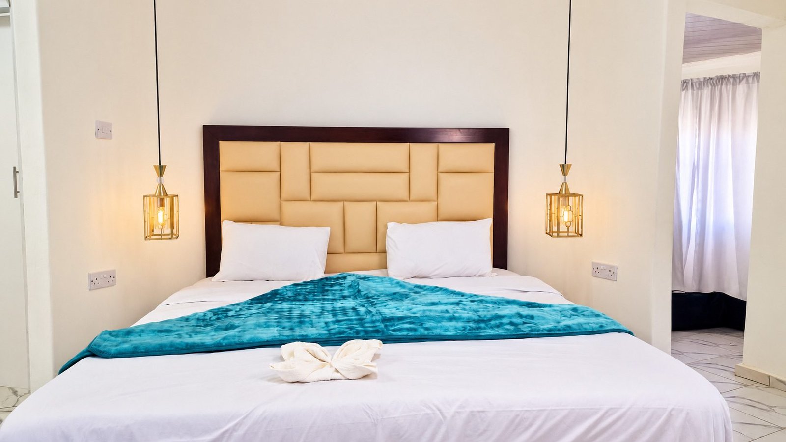Executive Chalet: king-size bed with a teal throw and pendant lamps