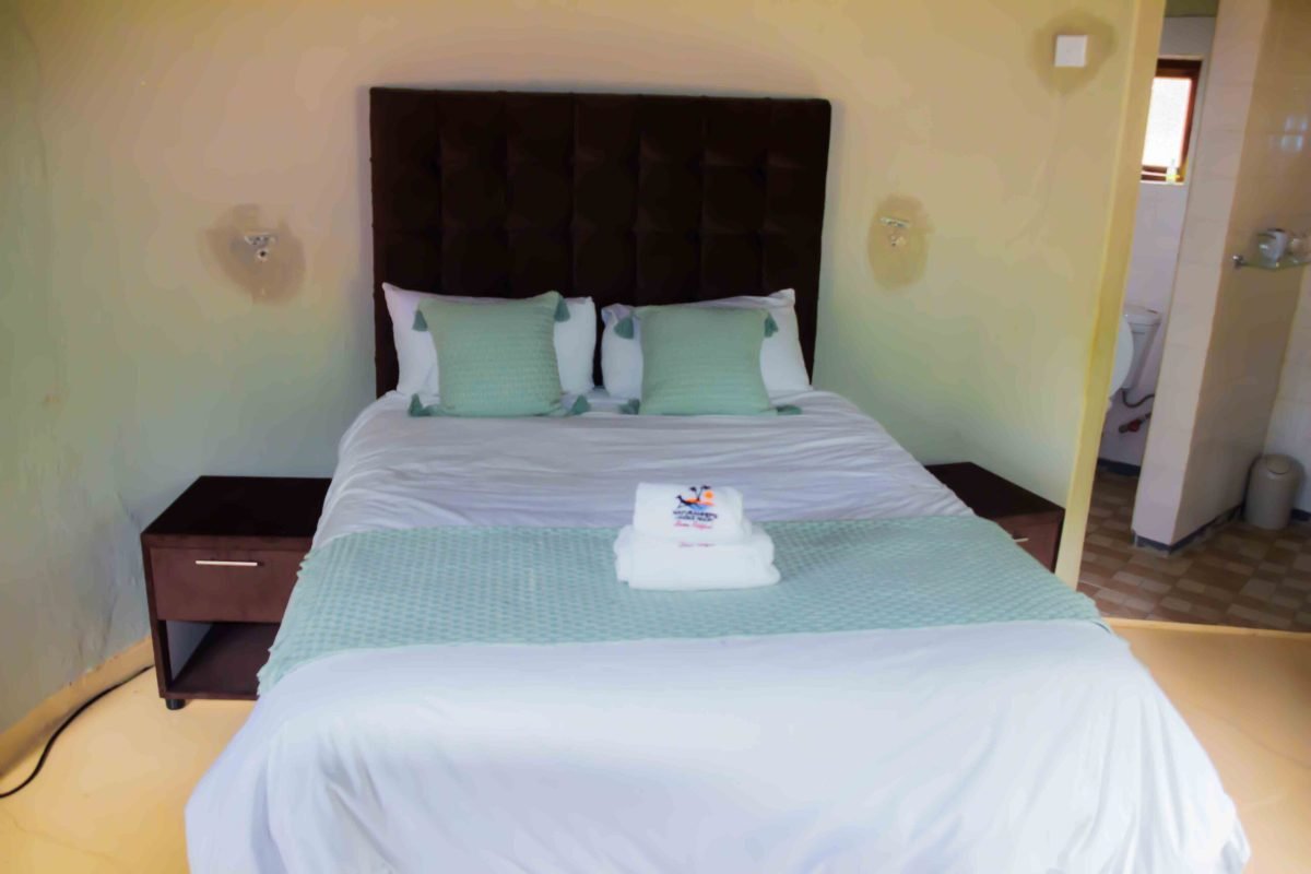 Chalet bedroom with a double bed, teal cushions and a folded towel