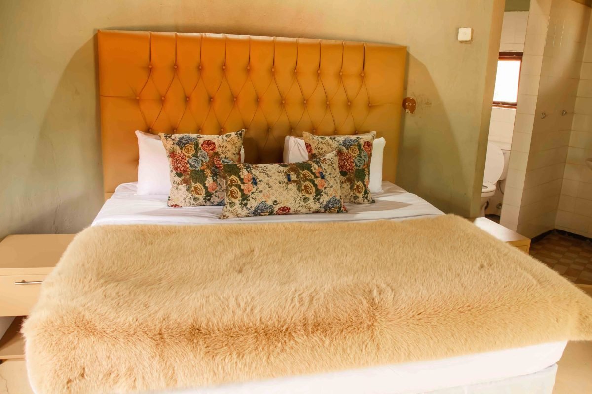 Chalet bedroom with a padded gold headboard and fleece throw