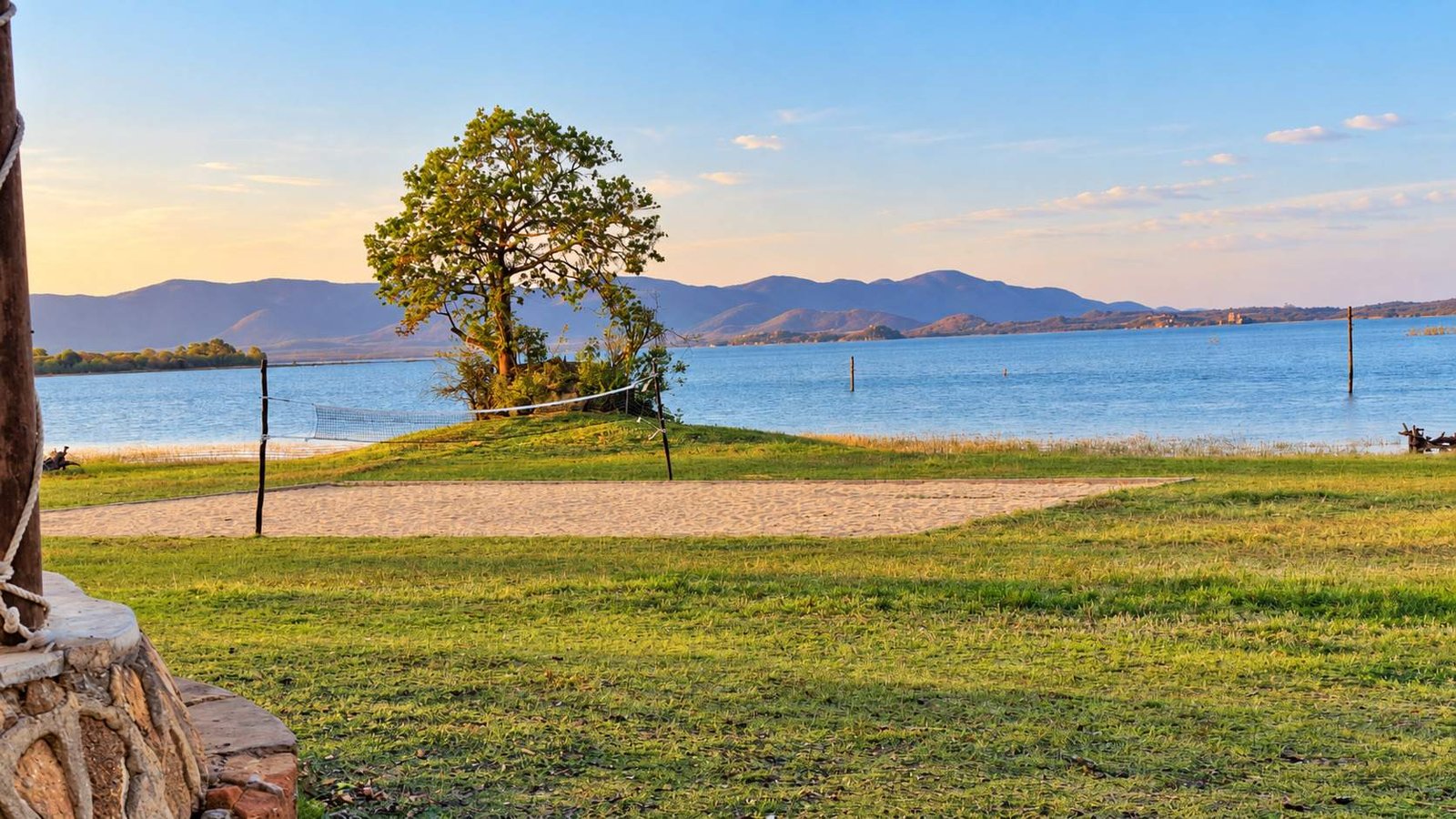 The lawn and shoreline at Mafuramhepo, Lake Mutirikwi and the hills beyond