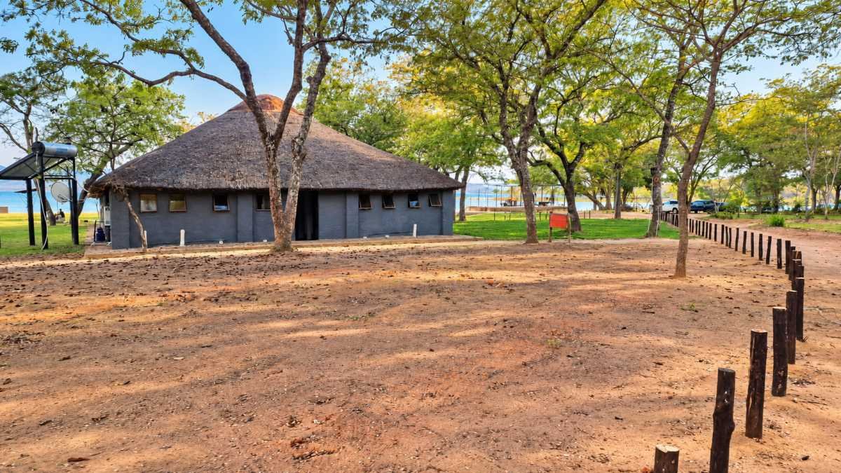 The thatched venue building on the lawn under the trees