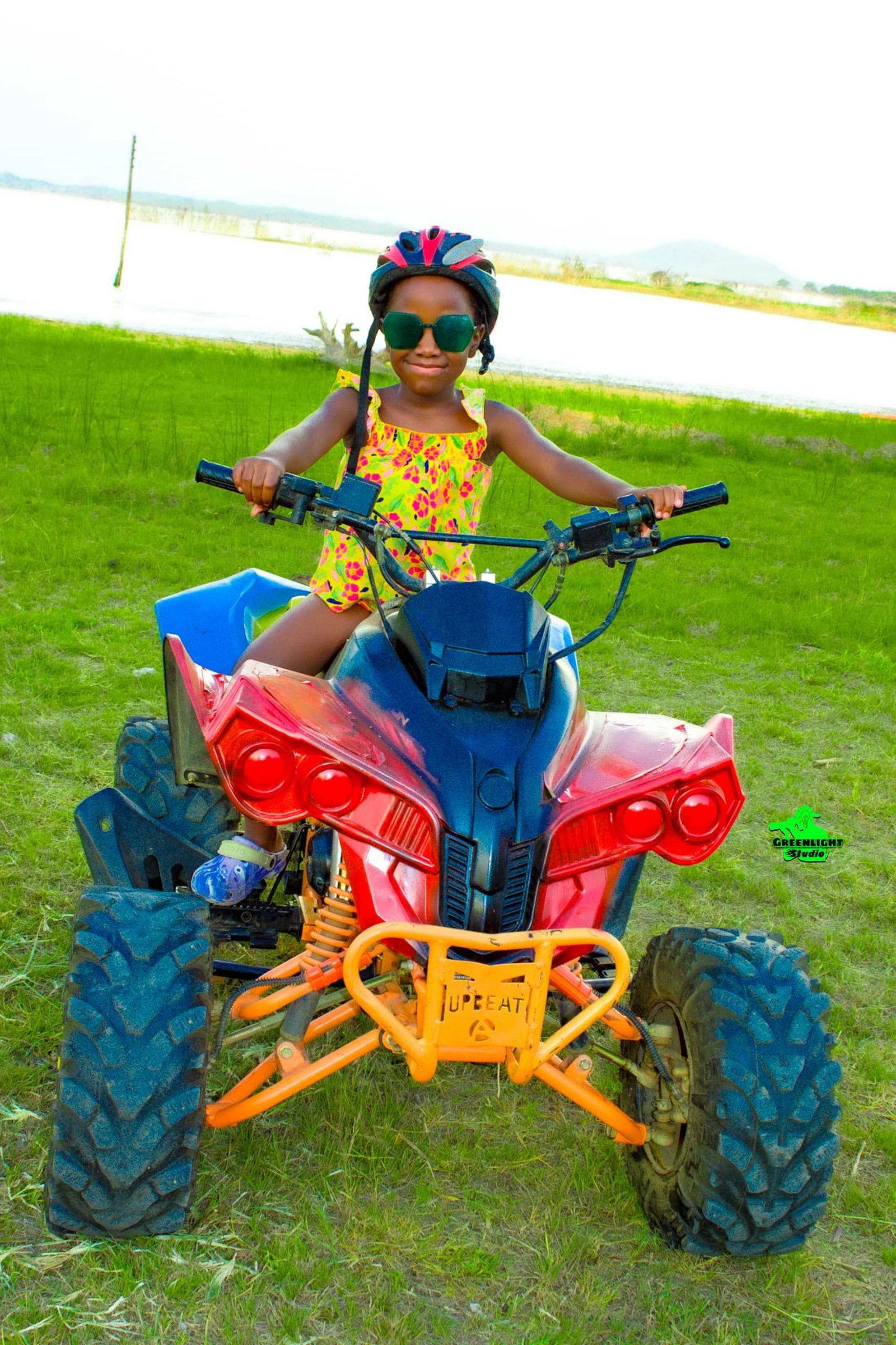 A young girl riding a quad bike on the lawn